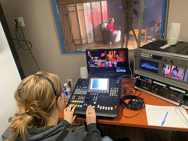 Grade 8 student, Lara, directing an episode of Heather TV in the new studio looking in on fellow student, Heather, the producer and host of the show.